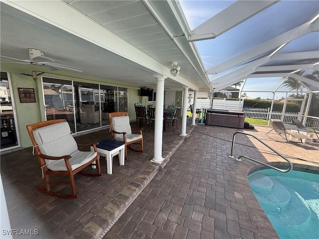 view of patio featuring a hot tub, a fenced in pool, ceiling fan, a lanai, and fence