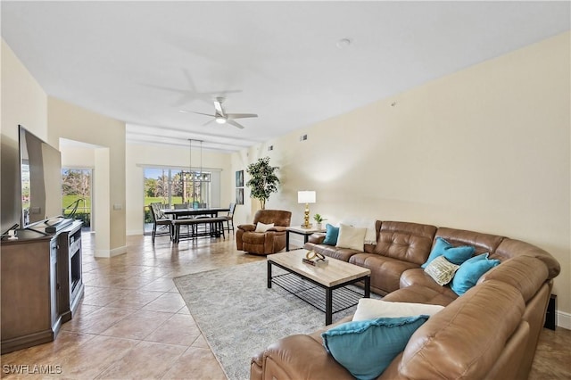 living room featuring light tile patterned flooring, ceiling fan, and baseboards