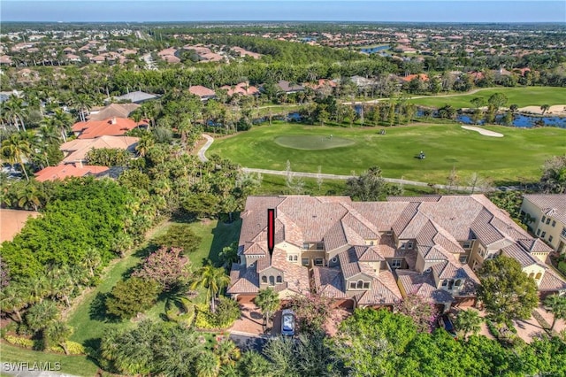 drone / aerial view featuring a residential view, view of golf course, and a water view