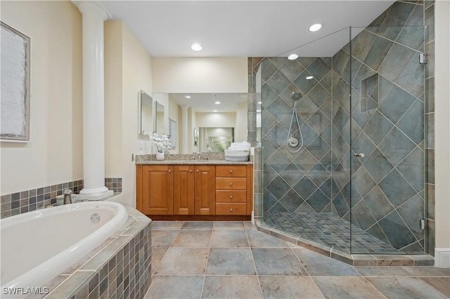 bathroom with a garden tub, recessed lighting, vanity, a stall shower, and ornate columns