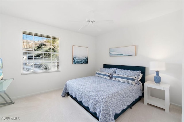 carpeted bedroom featuring baseboards and a ceiling fan
