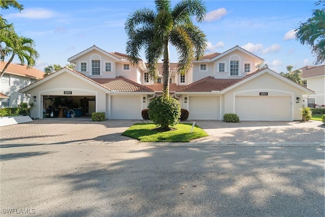 view of front of house featuring stucco siding, a tile roof, and decorative driveway