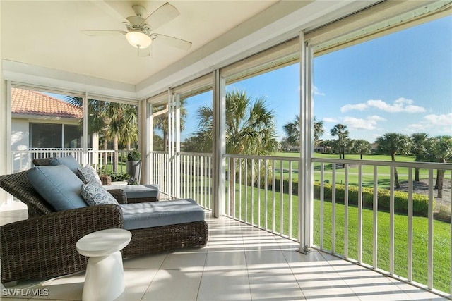 sunroom / solarium with tile patterned floors, a ceiling fan, and a wealth of natural light