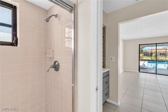 bathroom with tile patterned flooring, vanity, and tiled shower