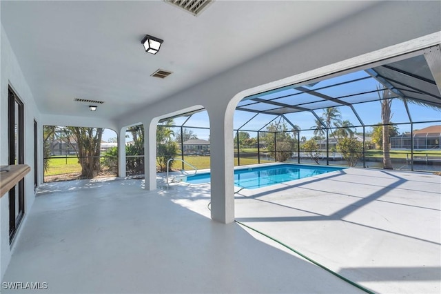 view of pool with glass enclosure and a patio area