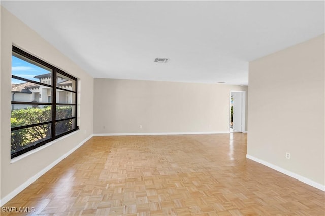 empty room with light parquet flooring and a healthy amount of sunlight