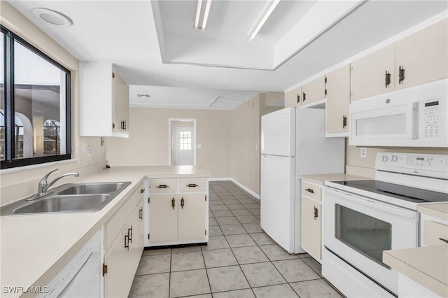 kitchen featuring sink, white cabinets, light tile patterned floors, kitchen peninsula, and white appliances