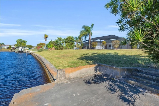 exterior space with a water view, a yard, and a lanai