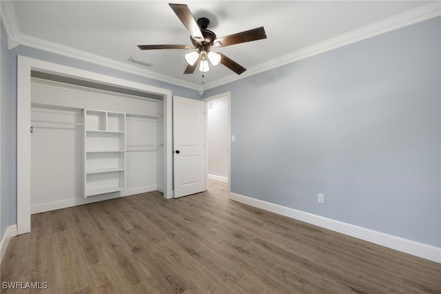 unfurnished bedroom featuring ornamental molding, a closet, light wood-style floors, and baseboards