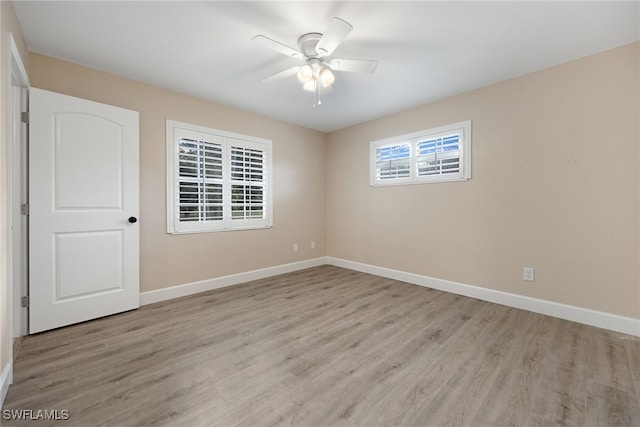 spare room with light wood-style floors, baseboards, and a ceiling fan