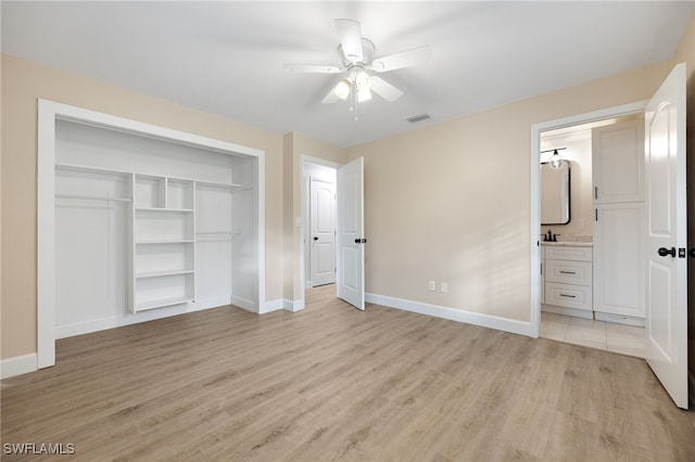 unfurnished bedroom featuring light wood-style floors, a closet, visible vents, and baseboards