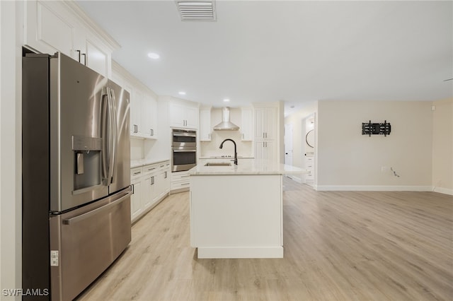 kitchen with a center island with sink, appliances with stainless steel finishes, and white cabinets