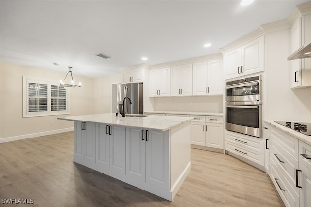 kitchen with visible vents, white cabinets, appliances with stainless steel finishes, an island with sink, and pendant lighting