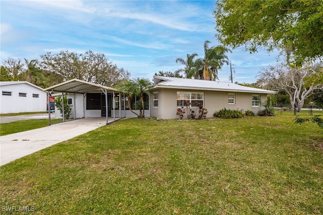 view of front of house featuring driveway, fence, a front yard, a carport, and stucco siding