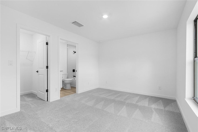 816 Gen D Macarthur Ave, Labelle, FL 33935 - unfurnished bedroom featuring carpet, a walk in closet, baseboards, ensuite bathroom, and recessed lighting