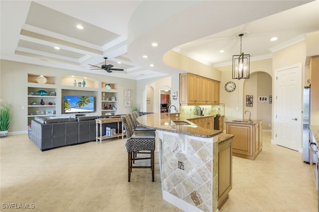 kitchen featuring sink, a kitchen breakfast bar, ceiling fan, kitchen peninsula, and hanging light fixtures