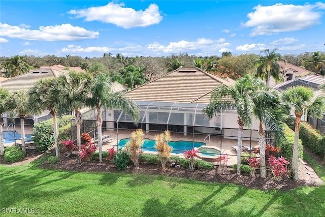 view of swimming pool featuring an in ground hot tub, a lanai, a lawn, and a patio area