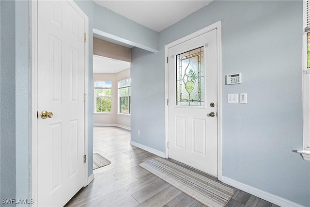 entryway with baseboards and wood finished floors