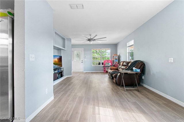 sitting room featuring visible vents, a ceiling fan, light wood-type flooring, and baseboards