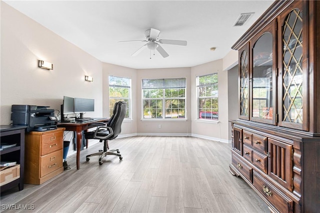 office space with visible vents, light wood-style floors, a healthy amount of sunlight, and ceiling fan