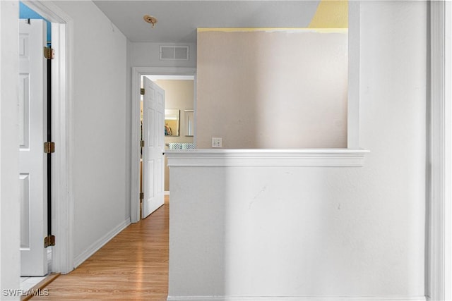 hall featuring light wood finished floors and visible vents