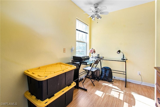 interior space featuring wood finished floors, baseboards, and ceiling fan