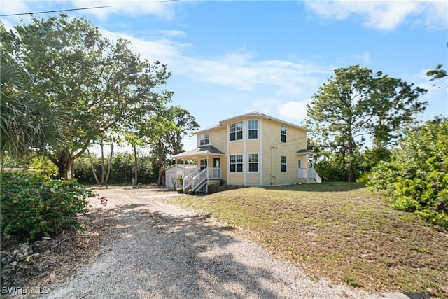 view of front of house featuring a front yard, an outbuilding, and driveway