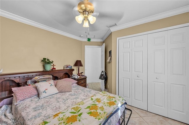 tiled bedroom with crown molding, ceiling fan, and a closet