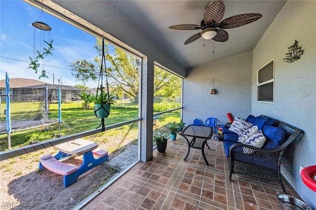 unfurnished sunroom featuring ceiling fan