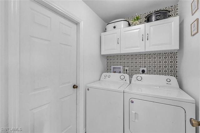 washroom featuring cabinets and washing machine and clothes dryer