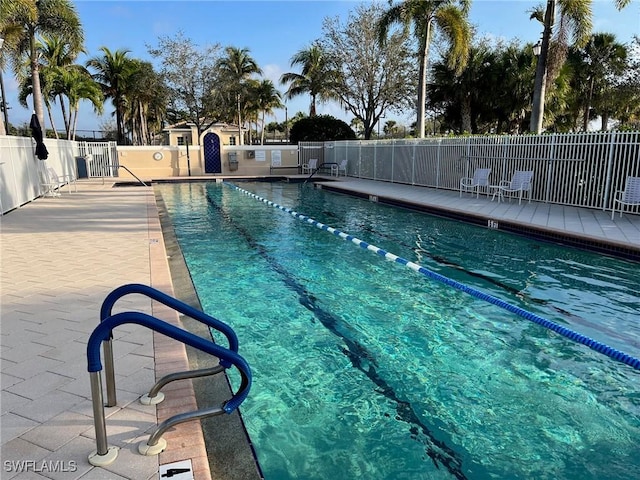 pool with a patio area and fence