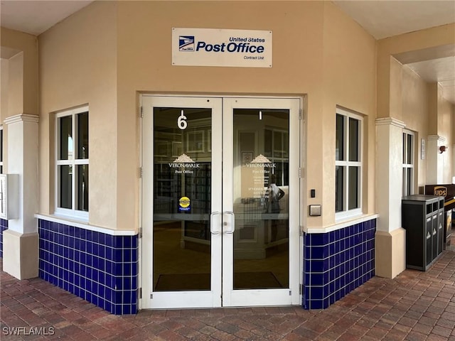 property entrance featuring french doors and stucco siding