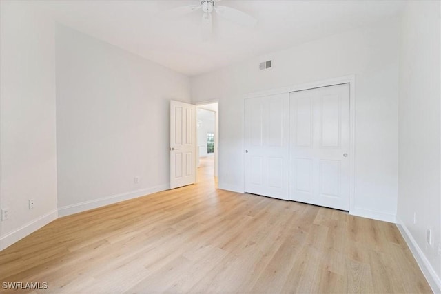 unfurnished bedroom with ceiling fan, light hardwood / wood-style floors, and a closet