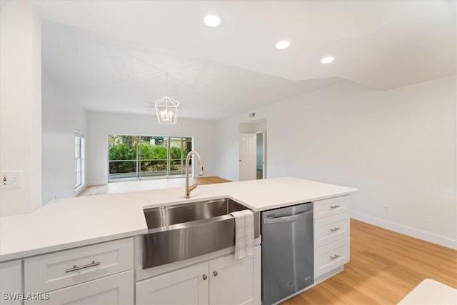 kitchen featuring stainless steel dishwasher, decorative light fixtures, sink, and white cabinets