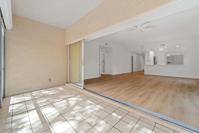 interior space featuring ceiling fan with notable chandelier and light hardwood / wood-style floors