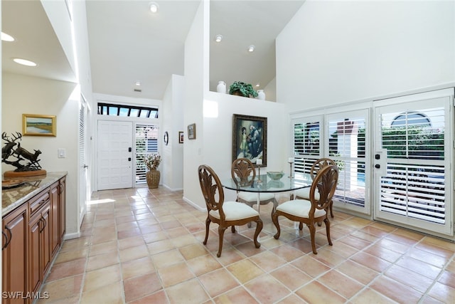 tiled dining room with french doors and a towering ceiling