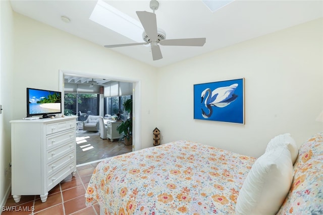 bedroom with ceiling fan, tile patterned floors, and lofted ceiling with skylight