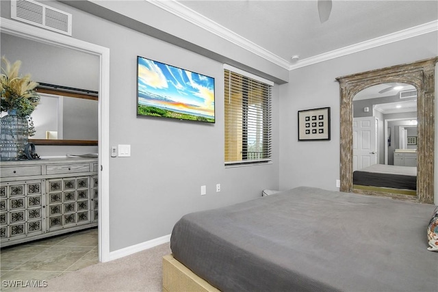 bedroom with baseboards, visible vents, arched walkways, light colored carpet, and crown molding