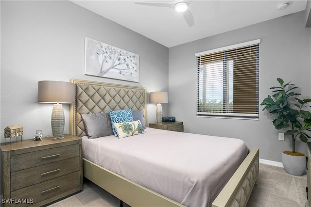 bedroom with light carpet, ceiling fan, and baseboards