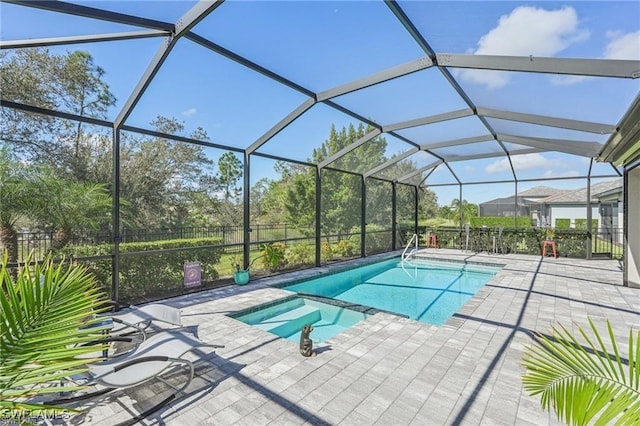 view of swimming pool with glass enclosure and a patio area