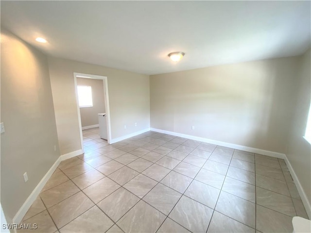 empty room with recessed lighting, baseboards, and light tile patterned floors