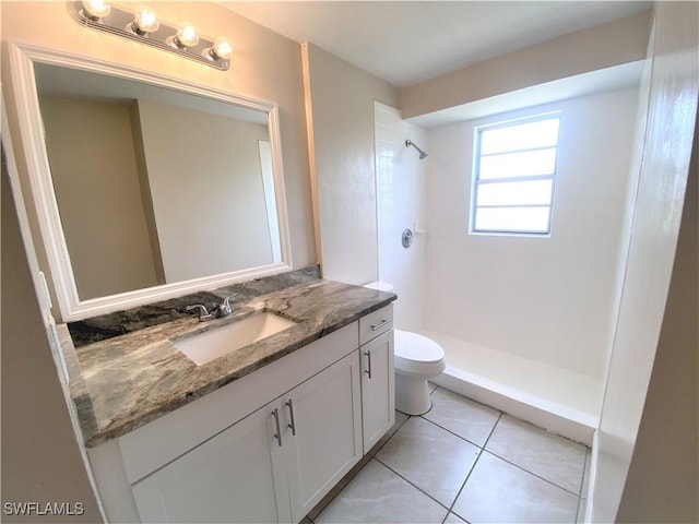 full bath with toilet, a stall shower, vanity, and tile patterned floors