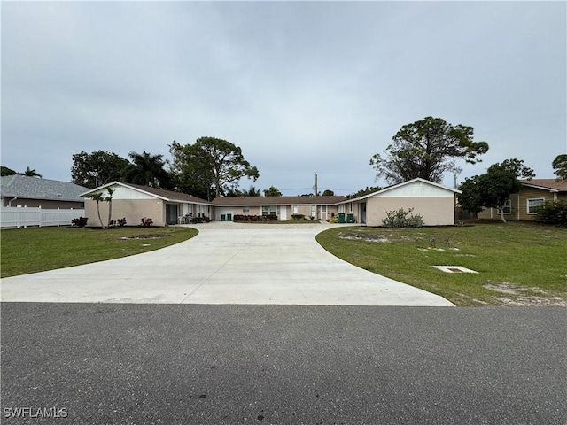 ranch-style house featuring driveway and a front lawn