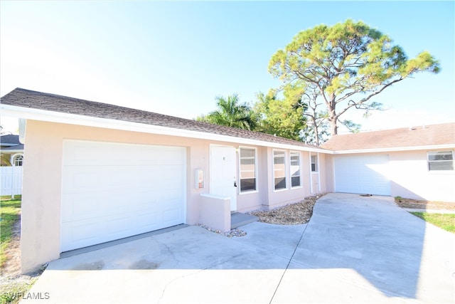 single story home with concrete driveway, an attached garage, and stucco siding