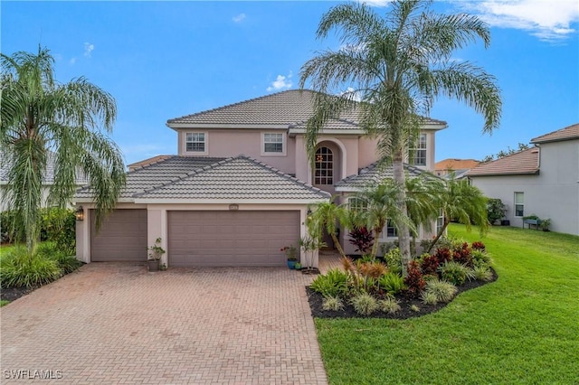 mediterranean / spanish-style home featuring a garage and a front lawn