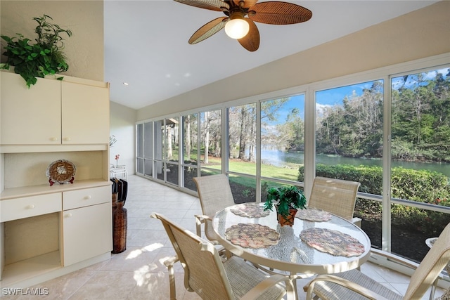 sunroom / solarium featuring lofted ceiling, ceiling fan, and a water view