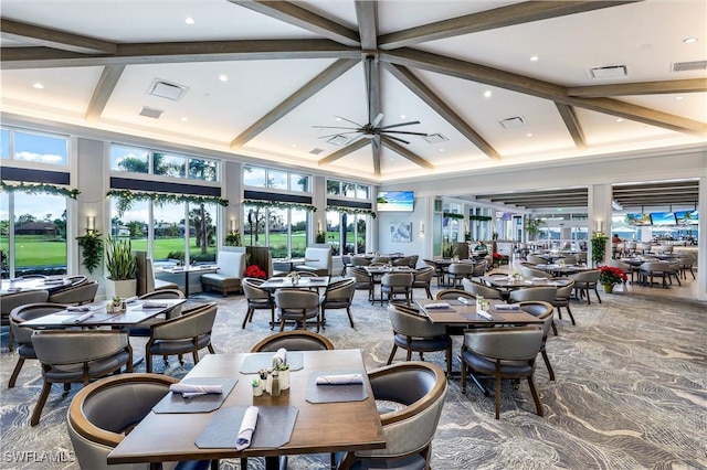 dining space with beamed ceiling and a high ceiling