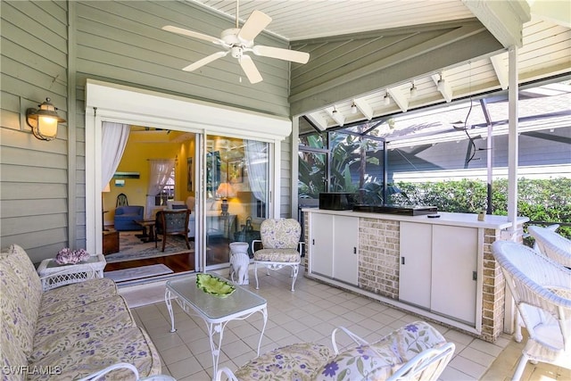 view of patio / terrace featuring ceiling fan and glass enclosure