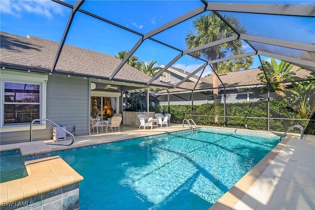 view of swimming pool with a patio, a lanai, ceiling fan, and a bar