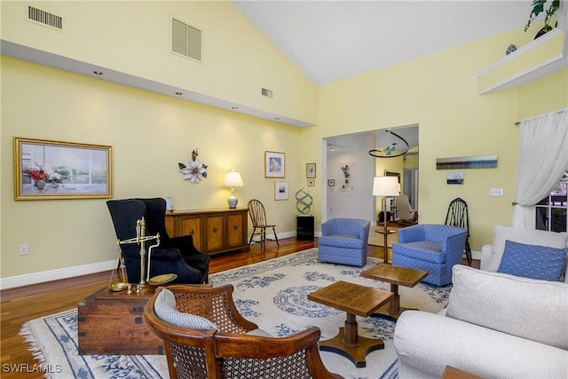 living room with wood-type flooring and high vaulted ceiling